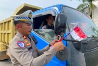 Foto : Polres Melawi membagikan bendera kepada masyarakat pengguna jalan di Tugu Juang II Nanga Pinoh