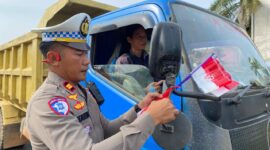 Foto : Polres Melawi membagikan bendera kepada masyarakat pengguna jalan di Tugu Juang II Nanga Pinoh