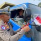 Foto : Polres Melawi membagikan bendera kepada masyarakat pengguna jalan di Tugu Juang II Nanga Pinoh